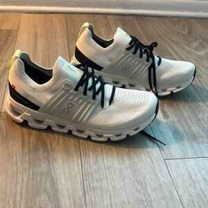 On Running White and Black Athletic Shoes with Streamlined Design